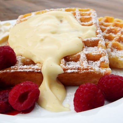 Brüsseler Waffel mit Puderzucker, Vanillecreme und Himbeeren